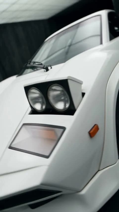 Aufgeklappte Doppelscheinwerfer eines weißen Countach, KI-Video